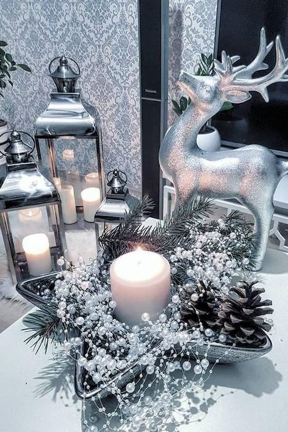 silver chirstmas table decor with a canle, deers and pines