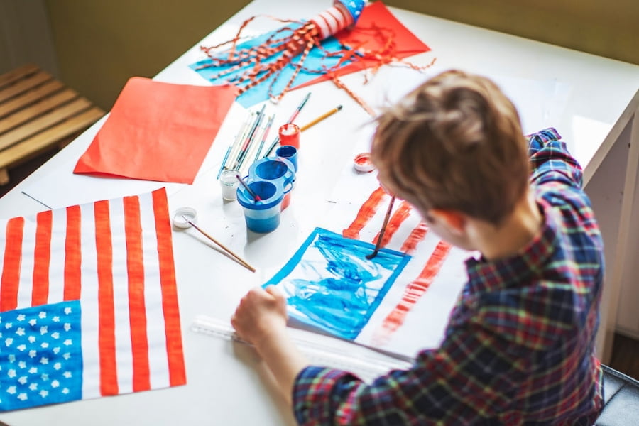 a kid making a paper american flag