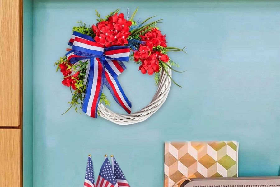 patriotic grapevine wreath with red flowers hang on wall