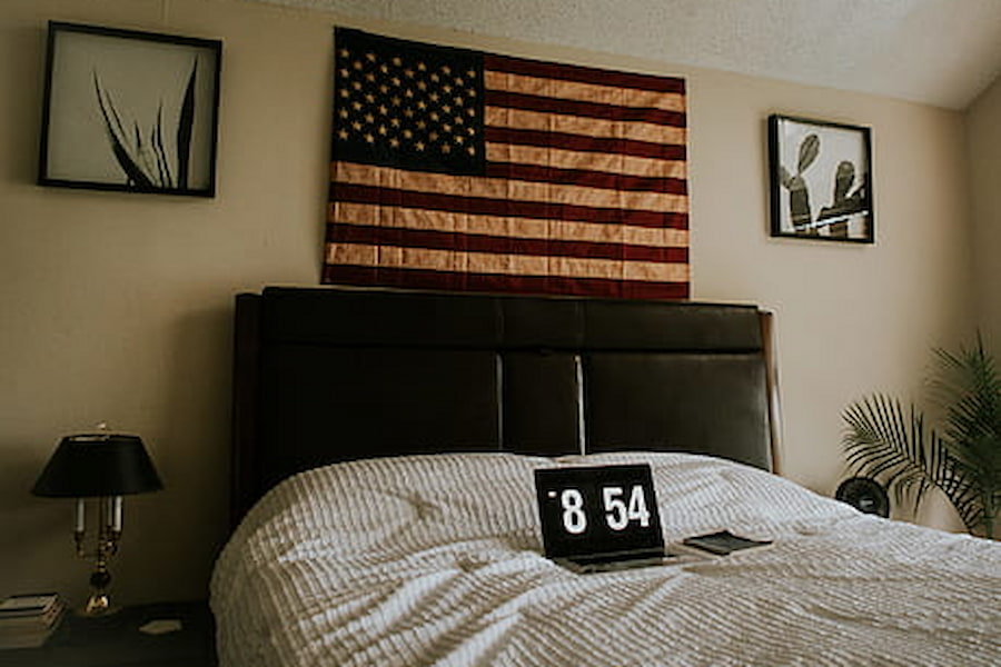 wall hanging american flag above a bed